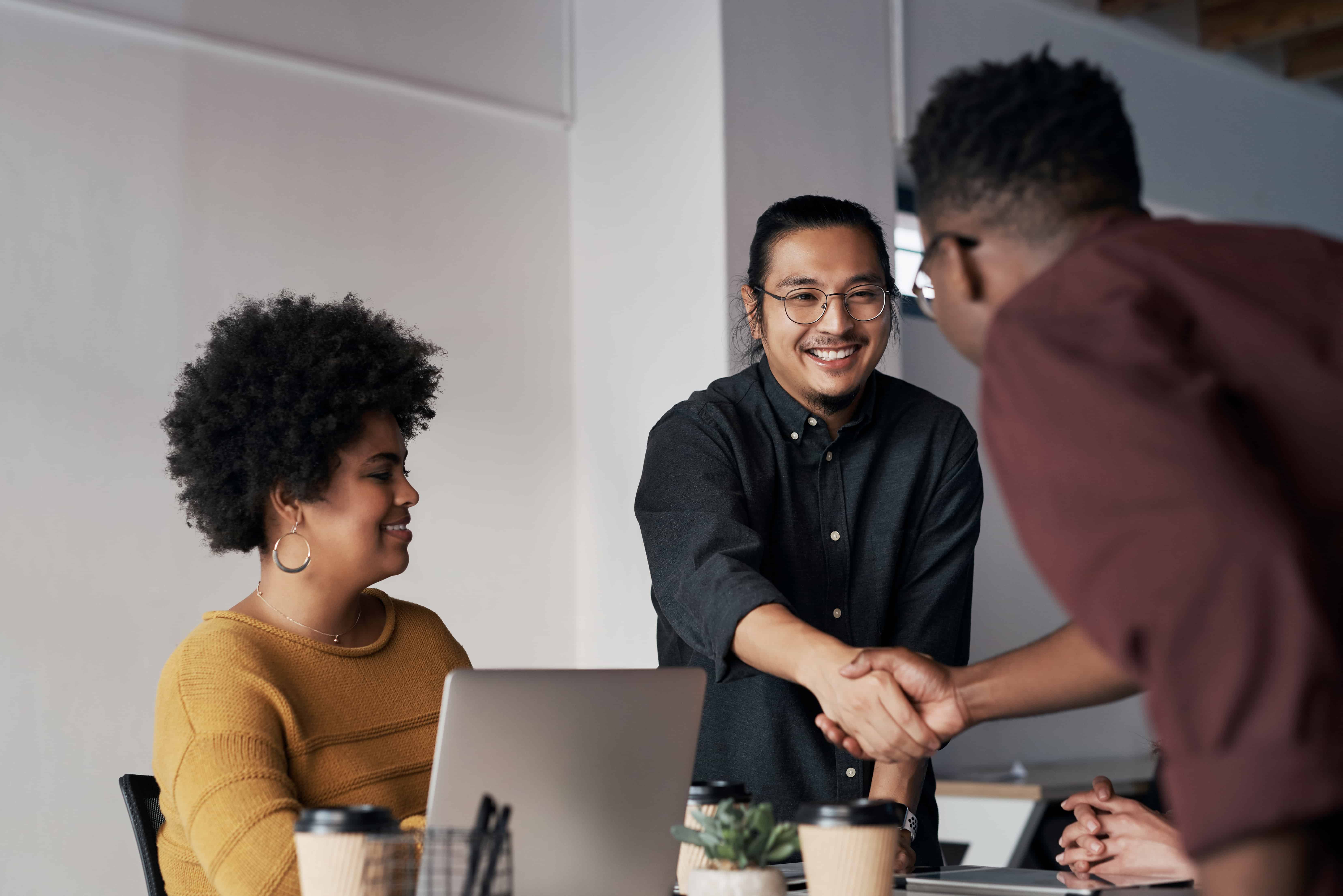 Creative office and business people with handshake agreement and deal for collaboration in design agency